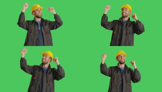 (中景)一名工人戴着安全帽跳舞并举手。背景为绿幕。高清在线视频素材下载