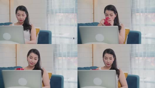 年轻的亚洲自由职业女性在家里的客厅休息时，用笔记本电脑查看社交媒体和喝咖啡。居家女性的生活方式概念。高清在线视频素材下载
