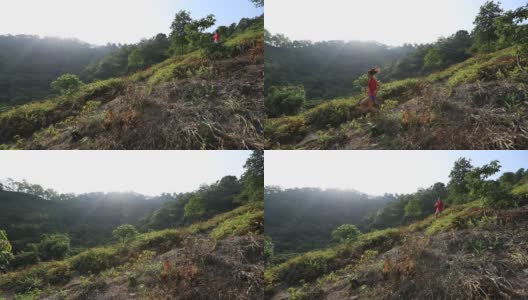 在热带森林的山坡上跑下山的女人高清在线视频素材下载