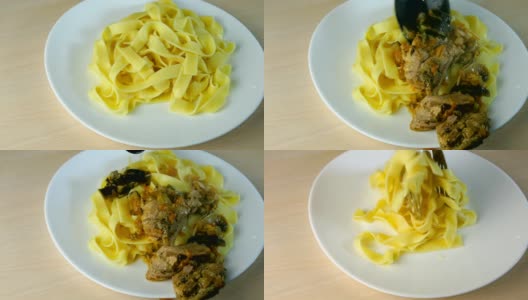 将意大利面或意大利面与厨房钳子一起放在白色的盘子里，加入炖菜并倒入香辣蘑菇汁。高清在线视频素材下载