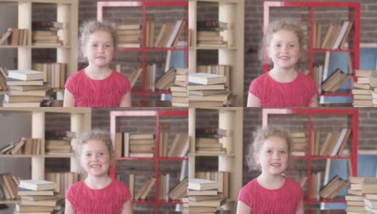 一个小女孩在学校教室里和一堆书的肖像。高清在线视频素材下载
