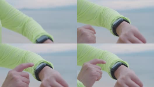 近距离观察亚洲健身女性的手在智能手表上设置健康跟踪，并在早上在海滩上慢跑时检查心率高清在线视频素材下载