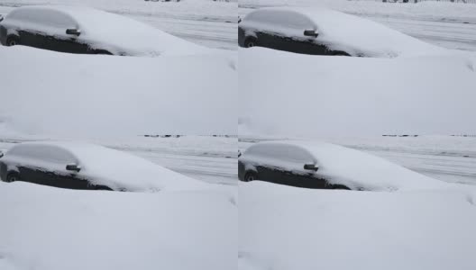 一辆被雪覆盖的黑色轿车停在一个巨大的雪堆后面的路上高清在线视频素材下载