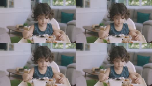 婴儿把米饭放进嘴里的快速镜头。高清在线视频素材下载