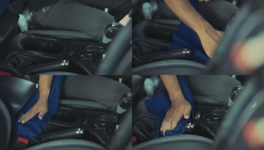 在汽车详细清洁服务期间，一位年轻人在清洁座椅坐垫时使用精细的布对汽车内部进行深层清洁。高清在线视频素材下载