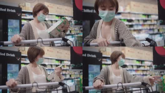 亚洲妇女使用污染口罩在超市购物车高清在线视频素材下载