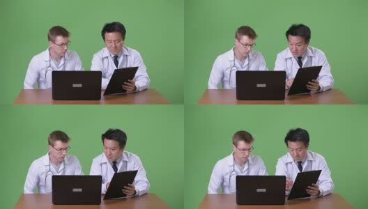 两个多民族医生在绿色背景下一起高清在线视频素材下载