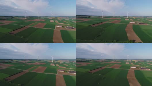 从空中俯瞰农田和风力发电机发电的景象。获得可替代风能的现代技术。鸟瞰图高清在线视频素材下载