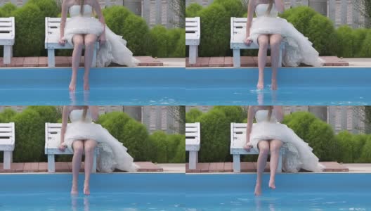 穿着白色婚纱的赤脚小女孩在游泳池旁高清在线视频素材下载