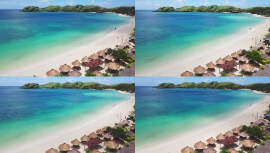 稻草沙滩伞和蓝色的海洋。从上面看海滩景色高清在线视频素材下载