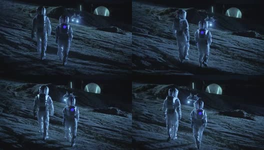 下面是两名宇航员穿着太空服行走在外星星球上仰望天空的照片。在背景基地与球型圆顶。其他世界殖民和太空旅行的概念。高清在线视频素材下载