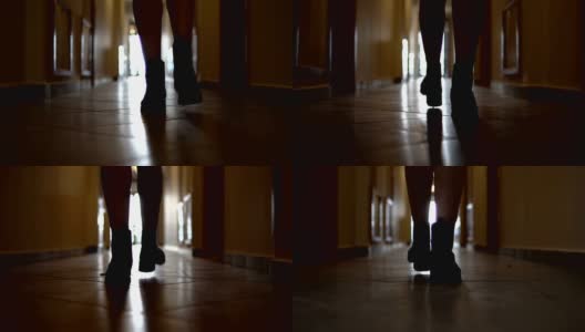 在黑暗的走廊里，跟随不认识的穿着靴子的女人的脚步，慢镜头高清在线视频素材下载