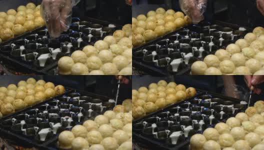 烹饪章鱼烧的慢动作过程。受欢迎的球形日本小吃。高清在线视频素材下载