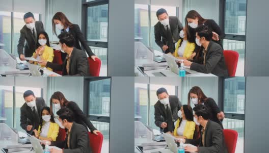 新常态的办公室生活方式亚洲商人和女商人戴着保护面罩社交距离头脑风暴会议一起纸图表和笔记本电脑一起团队成就概念股票视频高清在线视频素材下载