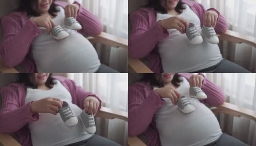 快乐的孕妇和即将出生的孩子在家里。高清在线视频素材下载