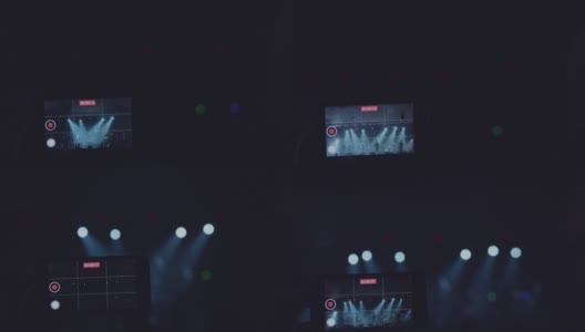 一个男人的手的特写镜头正在为一个乐队在夜店的霓虹灯舞台上表演录像。高清在线视频素材下载