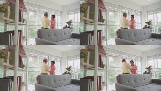 一对亚洲老夫妇在家里的客厅里一起跳舞来表达爱意。高清在线视频素材下载