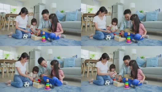 亚洲幸福的一家人坐在地板上，在客厅里一起玩儿童玩具。漂亮的父母，母亲和父亲花时间与年幼的女儿在家里。家庭活动关系概念。高清在线视频素材下载