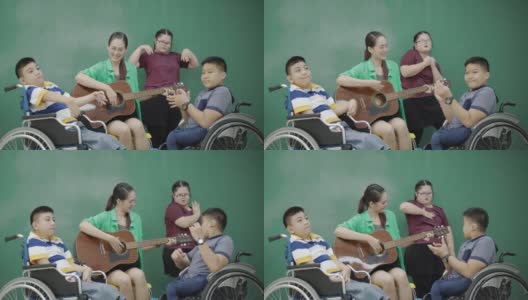 组亚洲残疾儿童在轮椅和自闭症演唱活动老师在教室弹吉他。提高学习技能的活动。贫困儿童教育高清在线视频素材下载