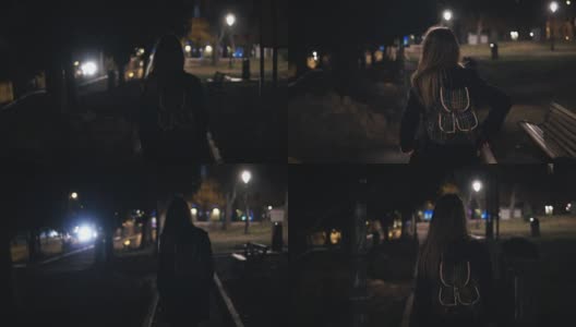 年轻时尚的女人走在深夜穿过黑暗的公园的背影。晚上一个人去高清在线视频素材下载