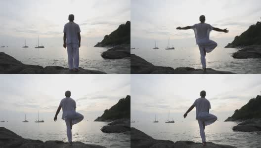 男子在海岸的石板上表演瑜伽动作高清在线视频素材下载