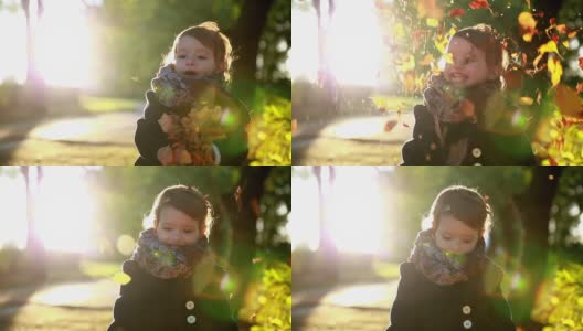 孩子在秋天的公园里扔黄叶。高清在线视频素材下载