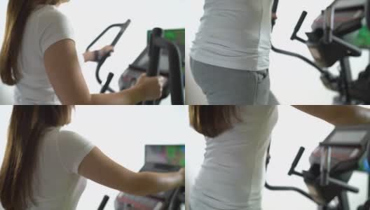 女人在电视前椭圆健身机上进行有氧运动高清在线视频素材下载