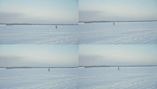 一个赤裸上身的男人的剪影在远处冰冻的河上奔跑。4 k。高清在线视频素材下载