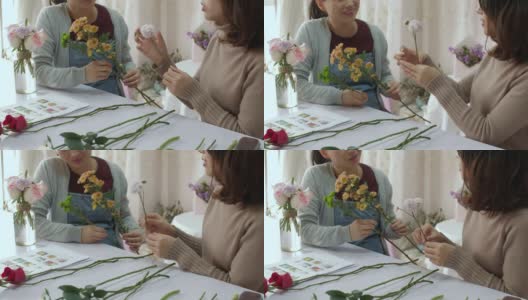 年轻的花商正在训练她的朋友如何做花束高清在线视频素材下载