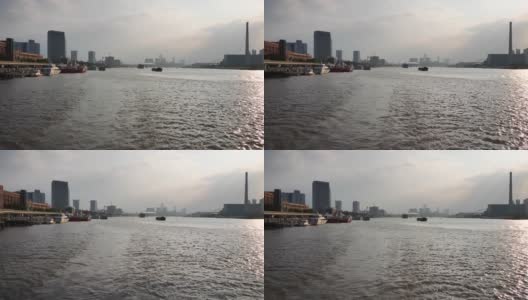 在夕阳下的上海黄浦江上航行，从游船尾部观看地标和船只，4k镜头，慢镜头。高清在线视频素材下载