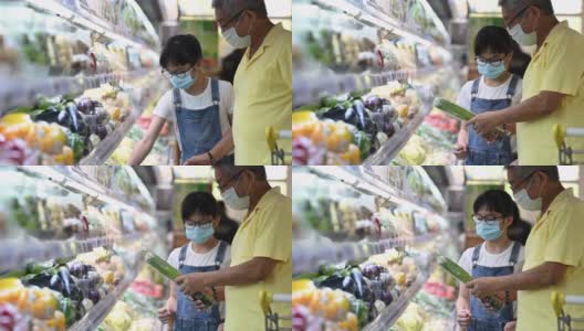 一个亚洲华人家庭周末在超市的冷藏区购买蔬菜高清在线视频素材下载