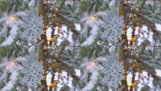 圣诞灯和雪花装饰在冬季公园的冷杉树上高清在线视频素材下载