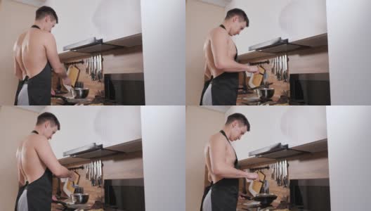 一个赤身裸体，穿着黑色围裙的男人在厨房里准备煎饼高清在线视频素材下载