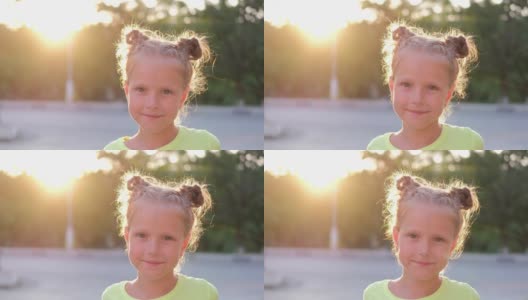 阳光年轻的金发女孩微笑着看着相机微笑，户外。肖像可爱快乐的孩子，慢动作。高清在线视频素材下载