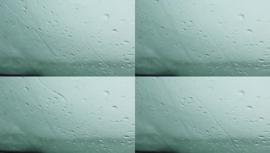 雨点沿着汽车的挡风玻璃落下。天气条件恶劣，秋天能见度有限。寒冷、潮湿、悲伤高清在线视频素材下载