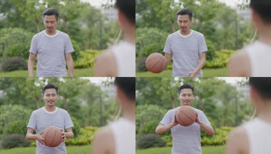 亚洲的父亲在早上在花园里给儿子传递篮球的慢动作高清在线视频素材下载