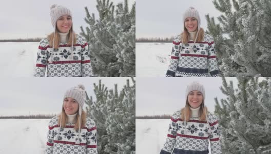一个可爱的女人在冬天沿着冷杉树走在雪地里的动作高清在线视频素材下载
