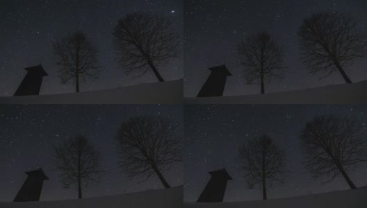 星星在夜空中移动，木制的钟楼和树木的剪影在冬天，天文时间流逝，摄影高清在线视频素材下载
