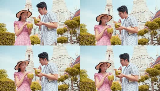 日本游客参观泰国寺庙(wat Aroon)和喝椰子汁。高清在线视频素材下载