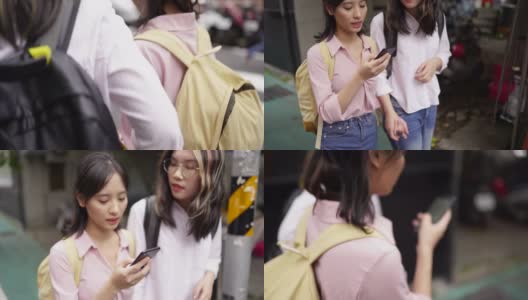 两个年轻的亚洲女孩走在街上用智能手机导航高清在线视频素材下载