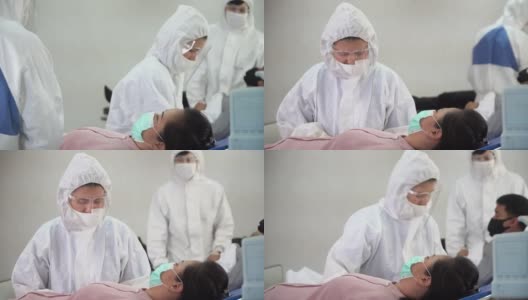一群身穿防护服的亚洲医生正在医院隔离病房的病床上检查和治疗因冠状病毒或covid - 19咳嗽的患者。流感爆发高清在线视频素材下载