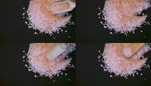 粉红色喜马拉雅盐。喜马拉雅粉岩盐木勺黑色背景。粉喜马拉雅盐的细粒高清在线视频素材下载