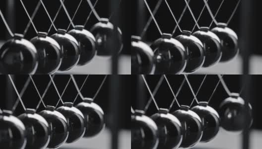 在黑色背景上拍摄运动中的灰色牛顿球高清在线视频素材下载