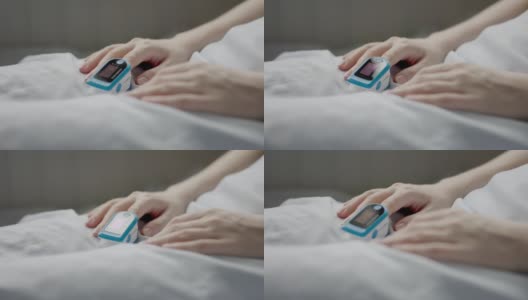 女性的手食指上有脉搏血氧计。女人躺在床上。医疗器械。血液中氧含量测定的概念高清在线视频素材下载