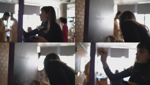 一个正在黑板上写字的年轻女子高清在线视频素材下载