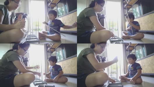 一个小男孩在家里的客厅里帮他妈妈组装家具高清在线视频素材下载