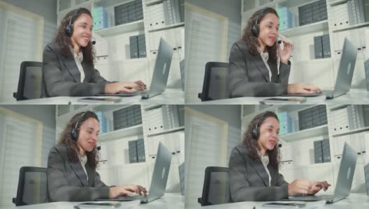 美丽的拉丁裔商务女性呼叫中心微笑，而工作在办公室。漂亮的年轻女员工穿着正装坐在工作场所的桌子上，用笔记本电脑交谈来支持客户。高清在线视频素材下载