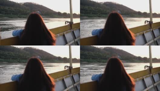 一名女性游客坐在湄公河上的一艘长尾船上的慢镜头后视镜高清在线视频素材下载