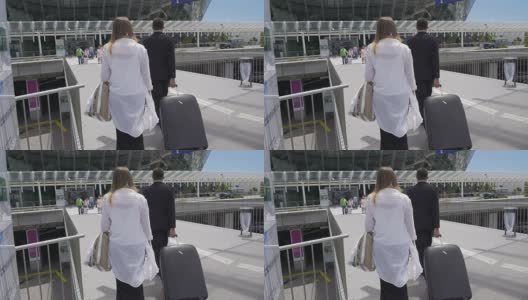 迷人的女性和保镖与她的行李走在机场，旅游高清在线视频素材下载