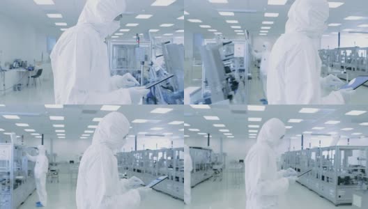科学家使用数字平板电脑和穿着防护服走过制造实验室与现代工业机械。产品制造工艺:制药，半导体，生物技术。高清在线视频素材下载